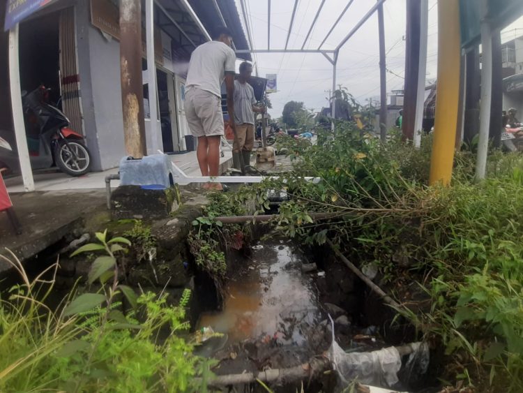 Bau menyengat dari parit tersumbat, camat bersiasat saluran air mampet di simpang lampu merah jalan bali dan jalan sisingamangaraja dikeluhkan warga. (foto: sinata/bismar)