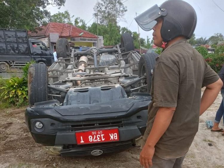 mobil terbalik usai menghindari tabrakan. (foto: sinata/fetra)
