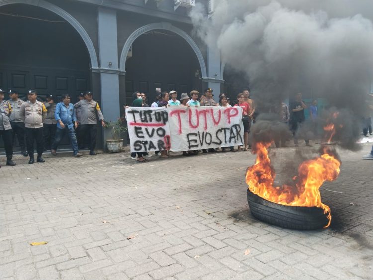 Massa desak pemerintah kota tutup seluruh thm di siantar massa unjukrasa di depan evo star. (foto: sinata/hendrik)